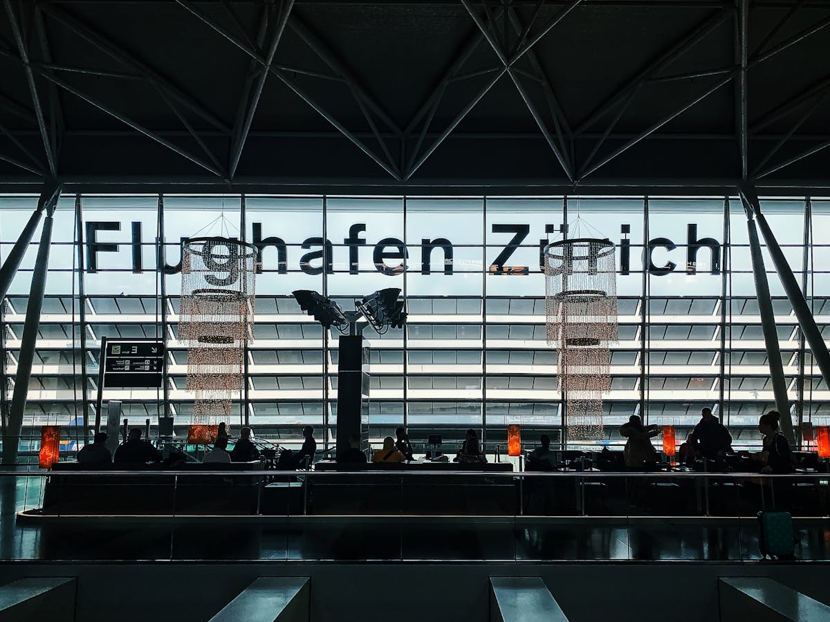 Travellers sitting in an airport departure lounge waiting for their flight