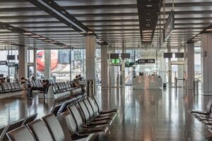 Modern airport terminal with departure gates and aircraft visible through glass windows