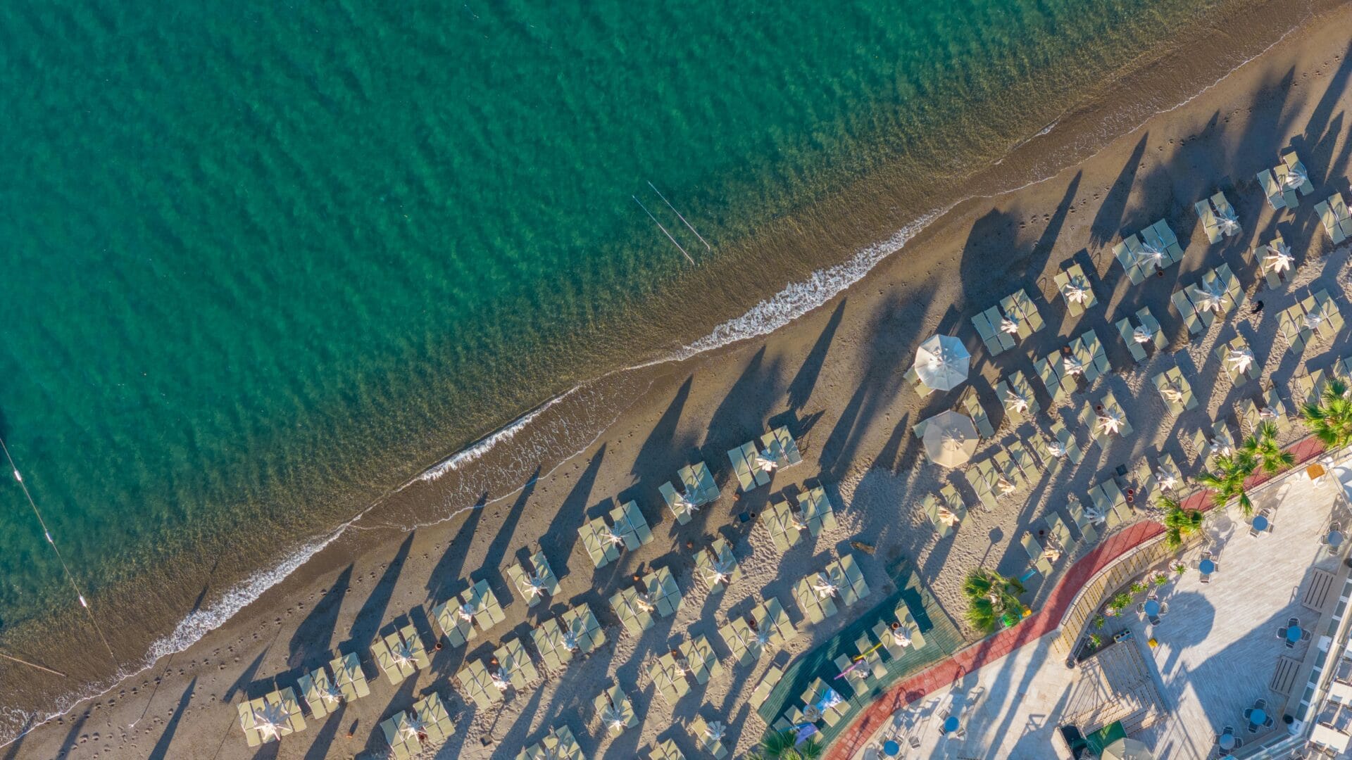 Aerial view of Bodrum beach with sun umbrellas and clear water