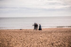 Family walking along Bournemouth beach on a sunny day, a popular UK school holiday destination
