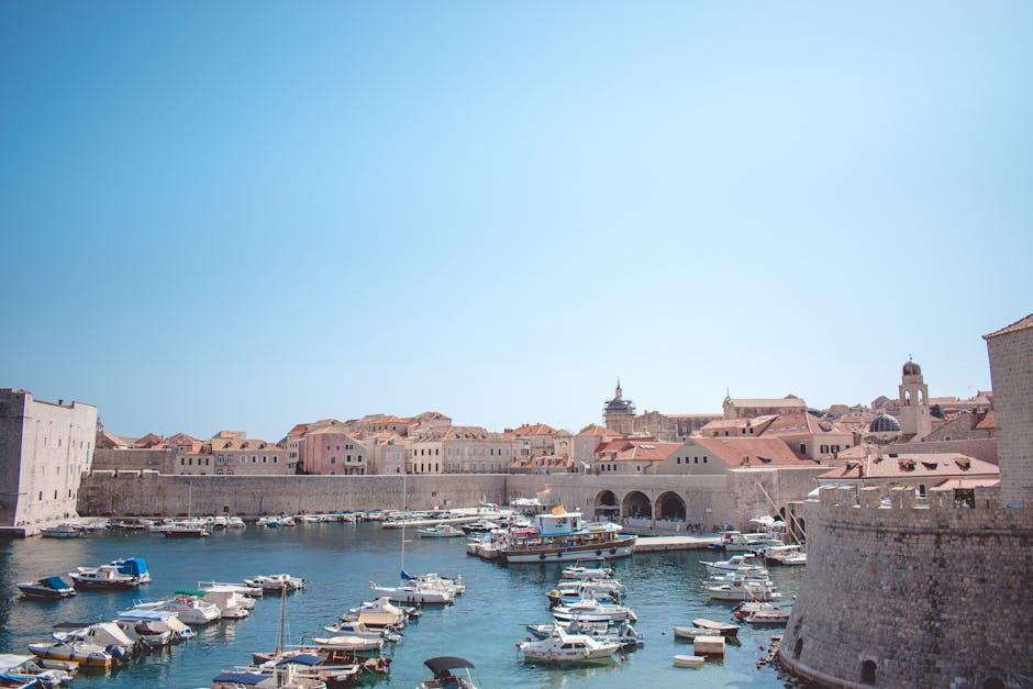 Historic harbour in Dubrovnik with boats moored against the medieval city walls