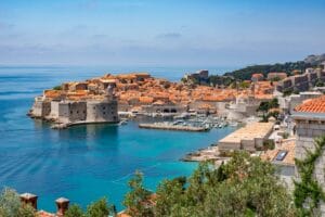 Dubrovnik's walled Old Town from above, with the harbour and clear Adriatic waters in the foreground
