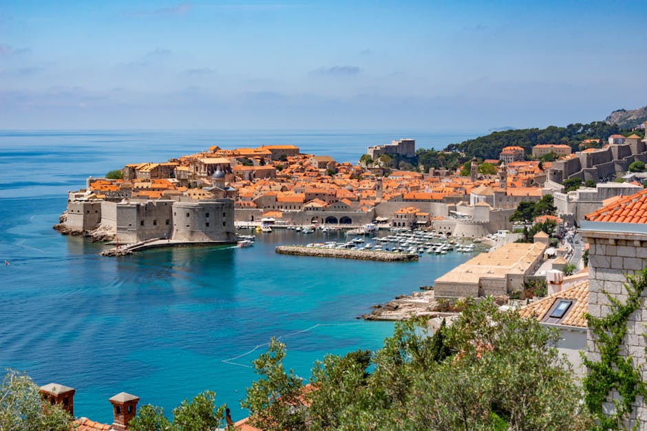 Dubrovnik's walled Old Town from above, with the harbour and clear Adriatic waters in the foreground