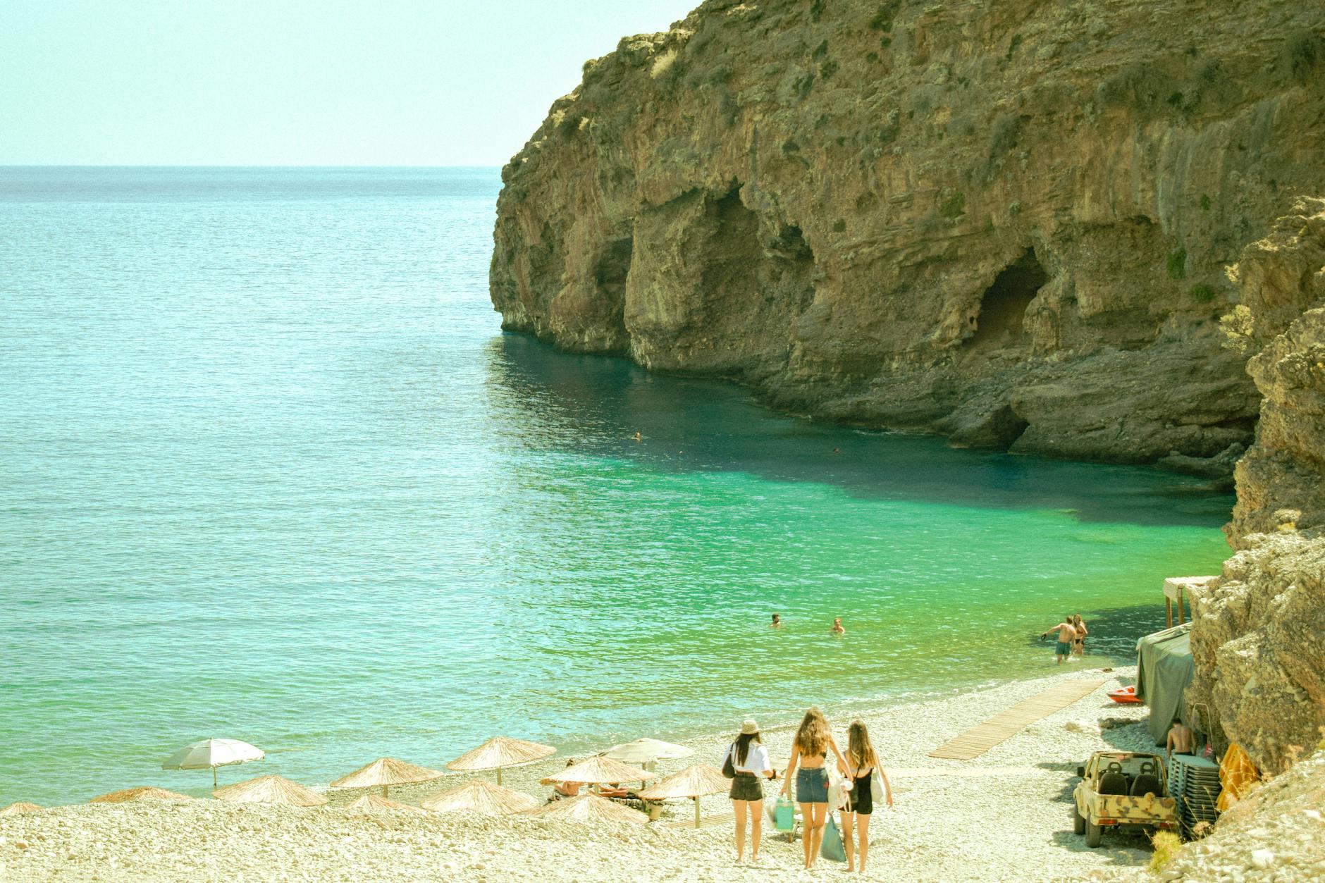 Scenic Greek beach cove with turquoise water and rocky limestone cliffs