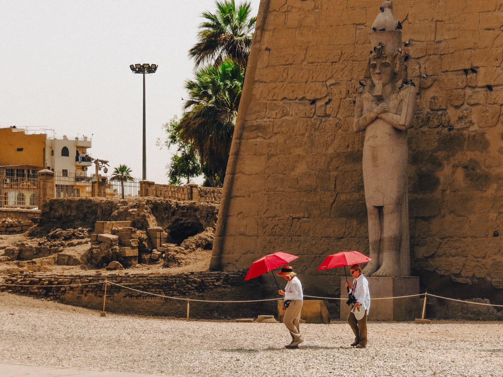 Luxor Temple illuminated at dusk with tourists exploring the site