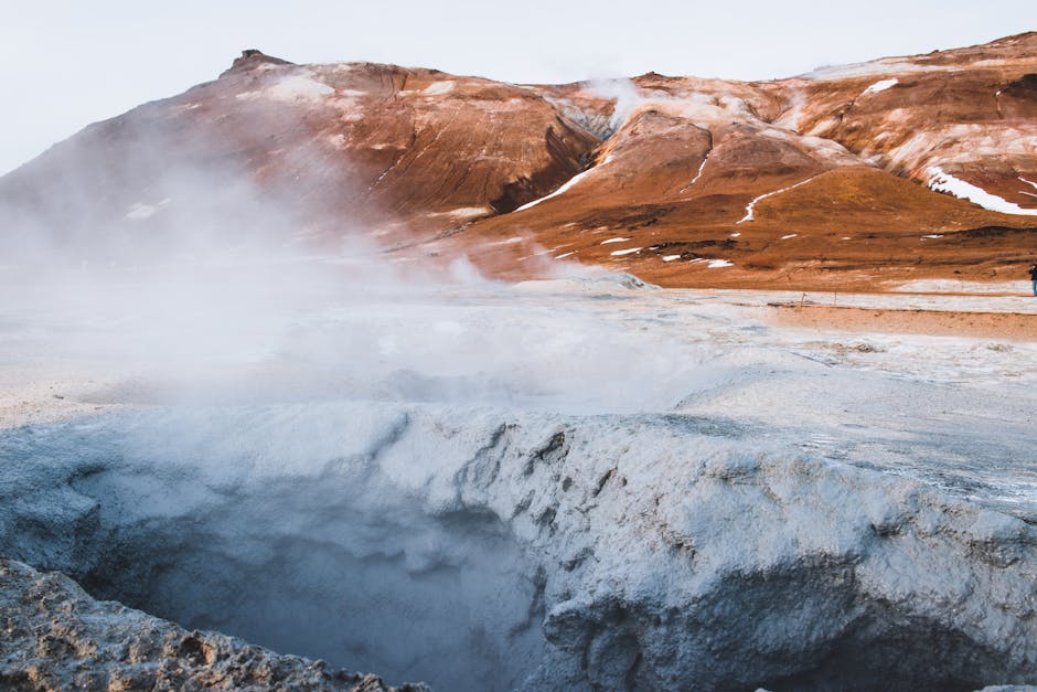 Vivid blue geothermal pool surrounded by volcanic rock formations in Iceland