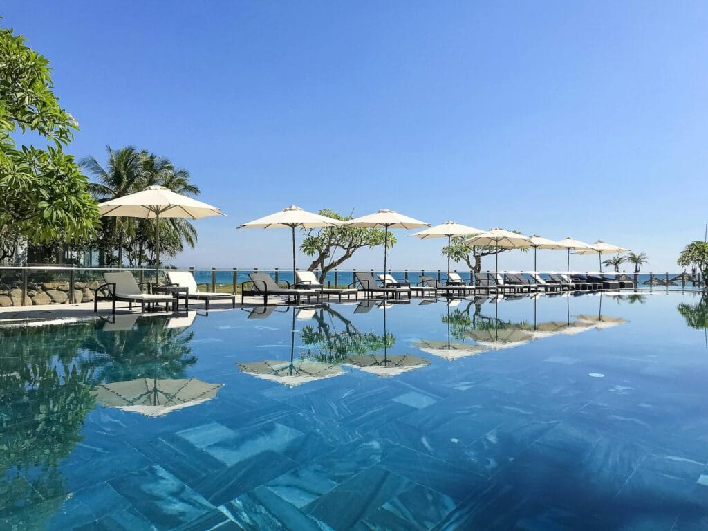Infinity pool with sun loungers and parasols at an all-inclusive resort overlooking the ocean