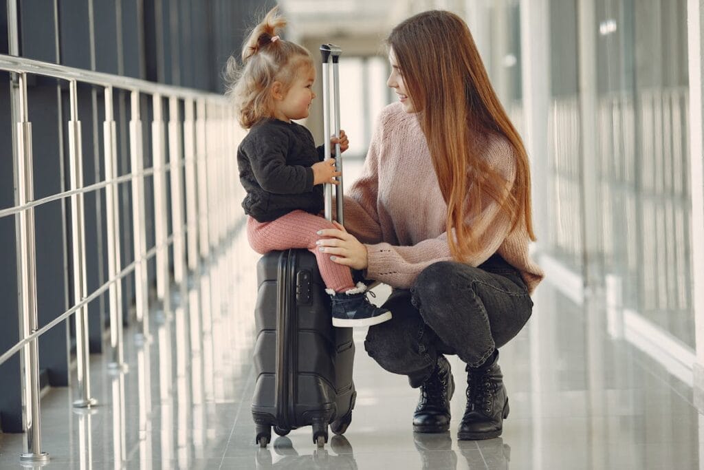 Mother and daughter smiling with suitcase at airport for Jet2 package holiday