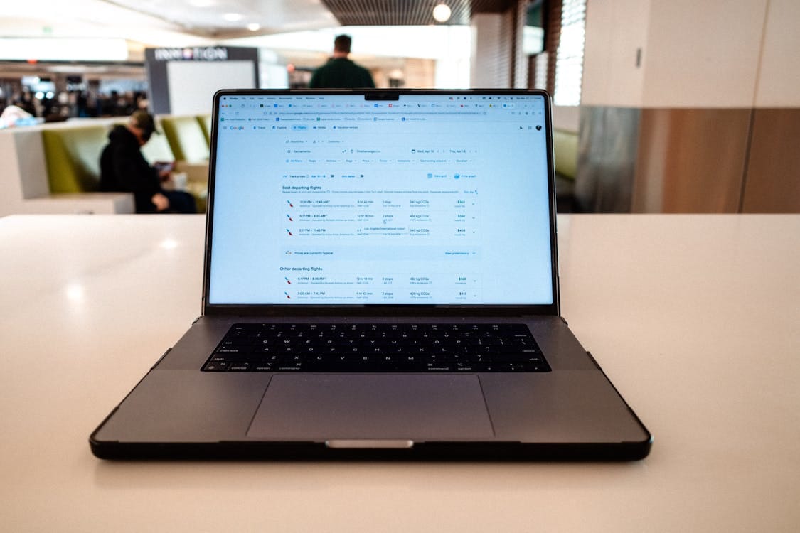 Laptop displaying flight schedules at airport lounge