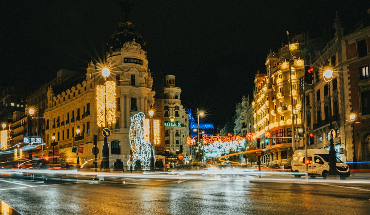 Gran Via boulevard in Madrid illuminated at night with decorated shopfronts and city lights