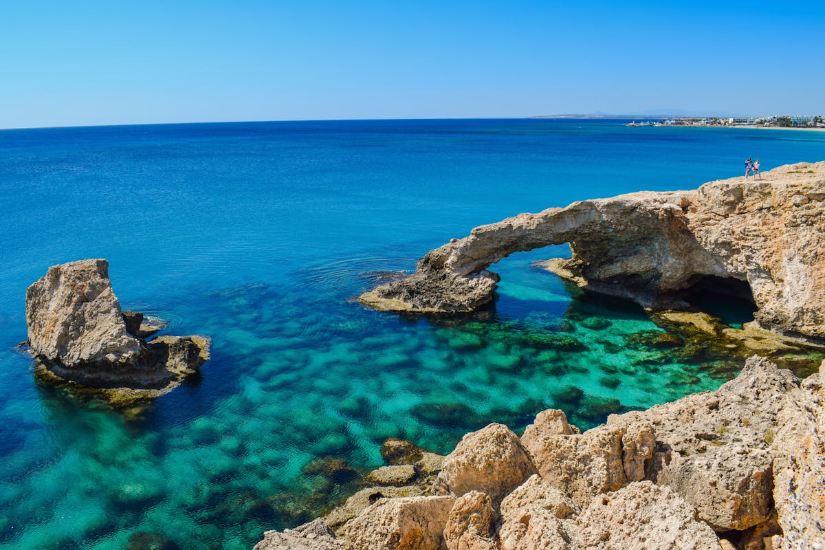 Iconic rock arch at Petra tou Romiou on the Cyprus coast, surrounded by turquoise sea