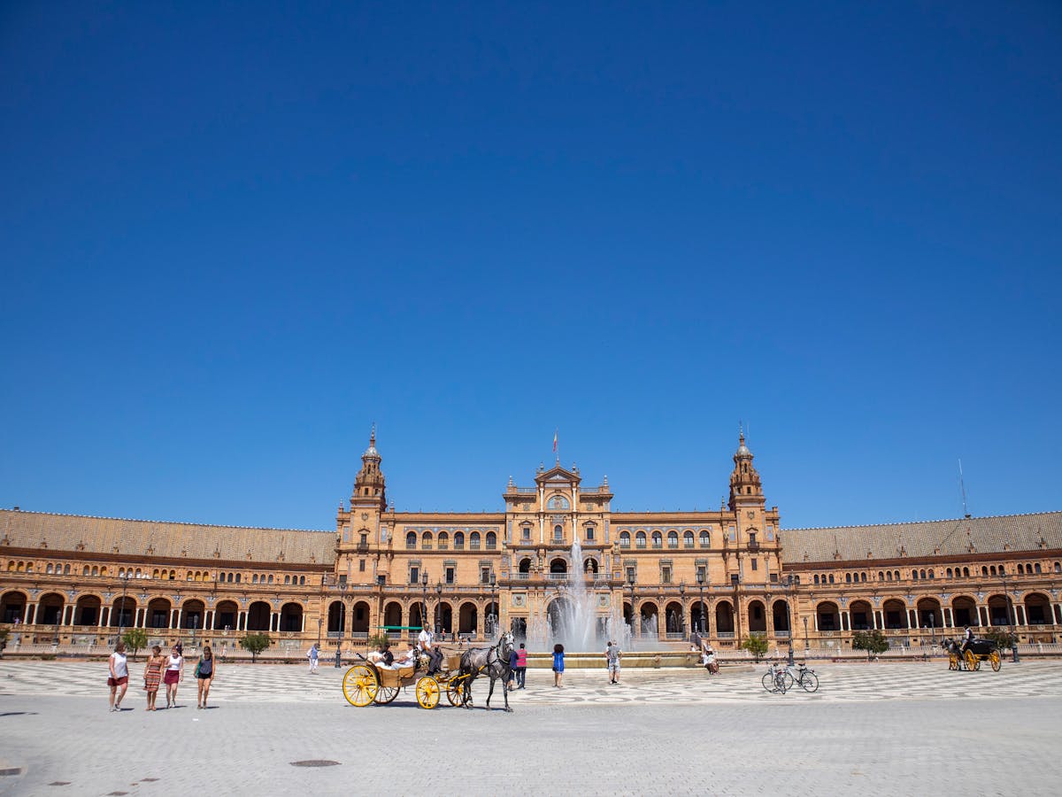 Plaza de Espana in Seville, Spain, ornate curved building under bright blue sky
