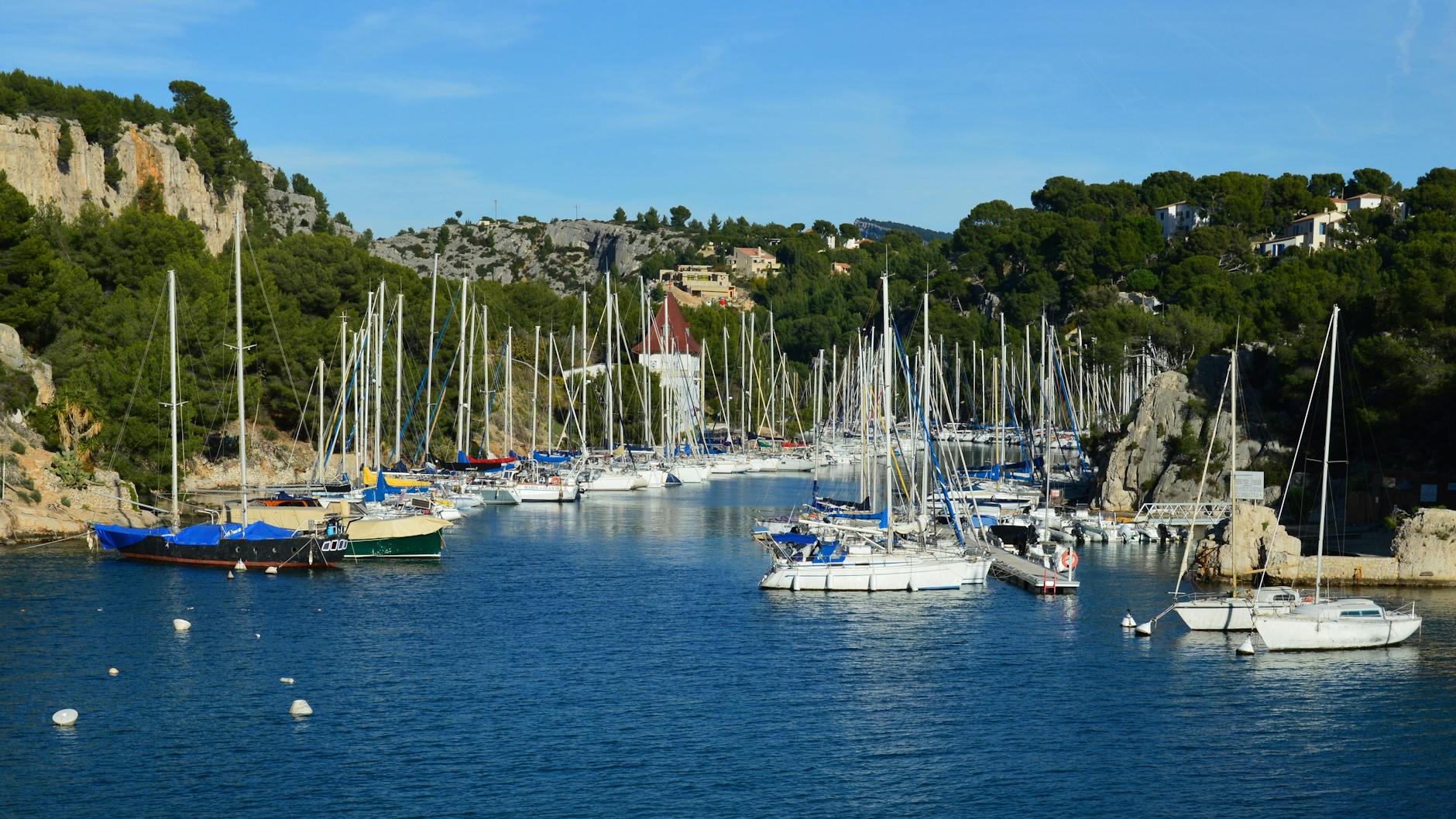 The harbour at Cassis, Provence, with sailboats and limestone cliffs, 30 minutes from Marseille by train.