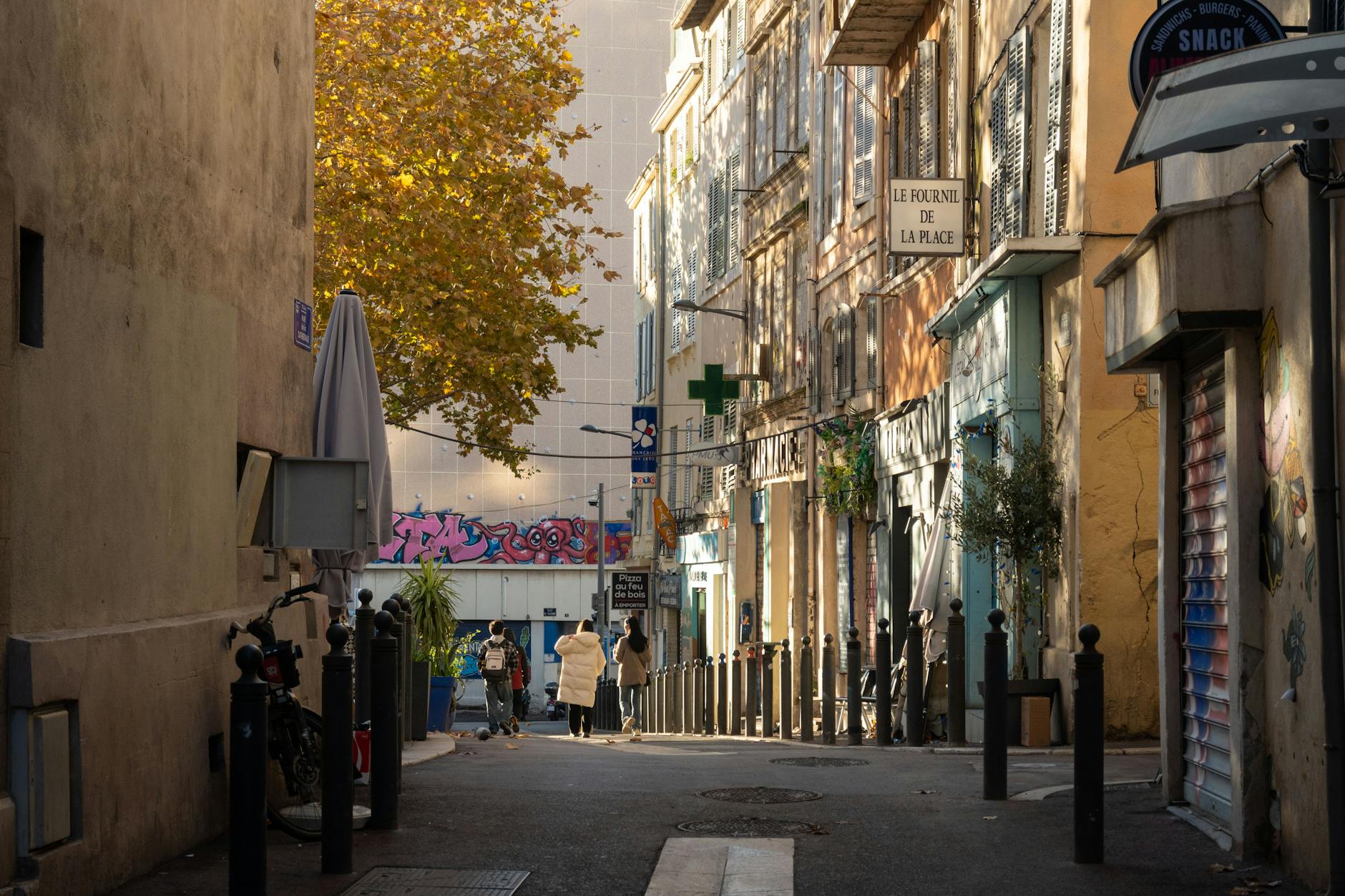 A street in central Marseille with Provençal architecture, local shops, and autumn afternoon light.