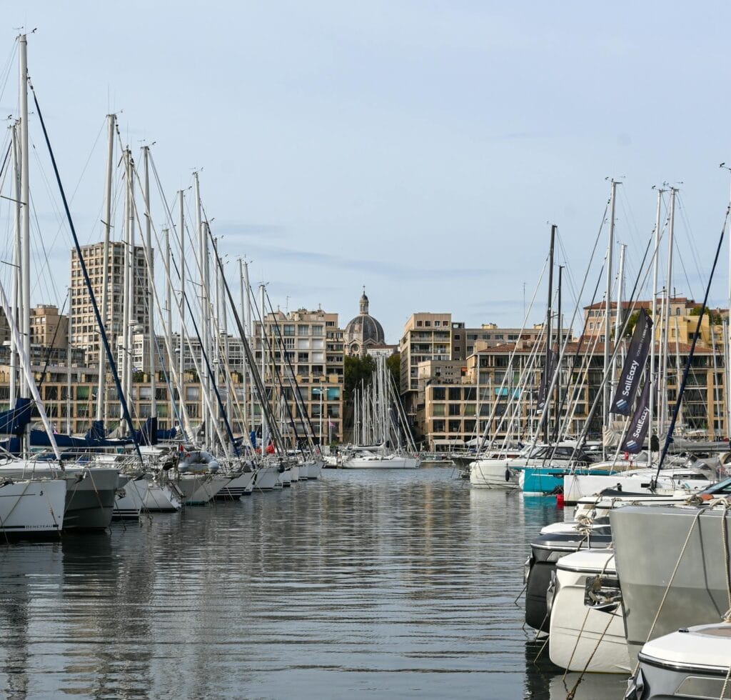 Stunning view of sailboats docked at the Old Port of Marseille with cityscape backdrop.