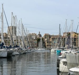 Stunning view of sailboats docked at the Old Port of Marseille with cityscape backdrop.