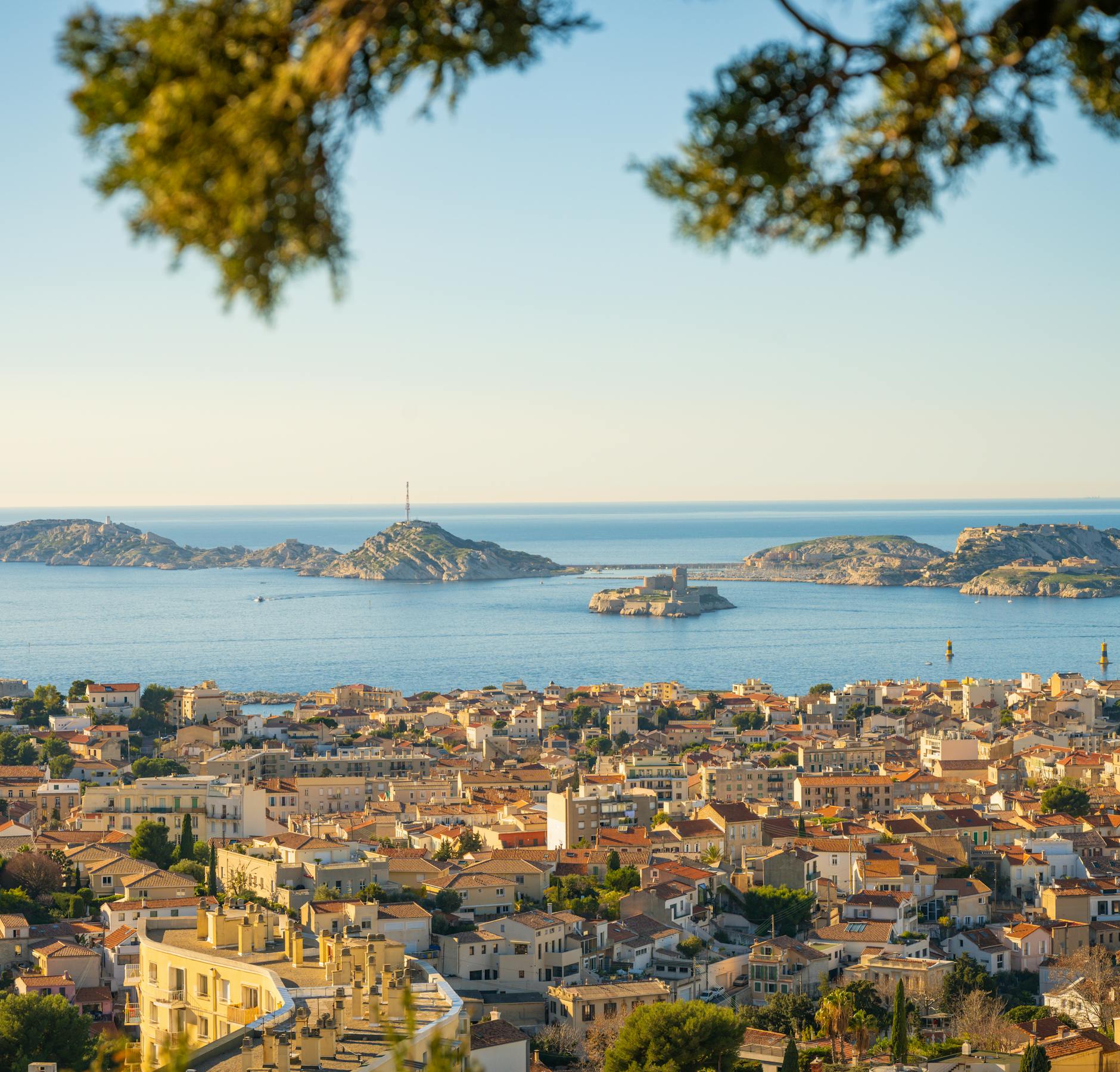 Panoramic view of Marseille city with the Frioul islands and Mediterranean Sea in the distance.