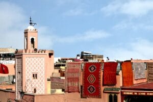 Marrakech rooftops with a pink minaret and Berber rugs hanging in the sun, Morocco