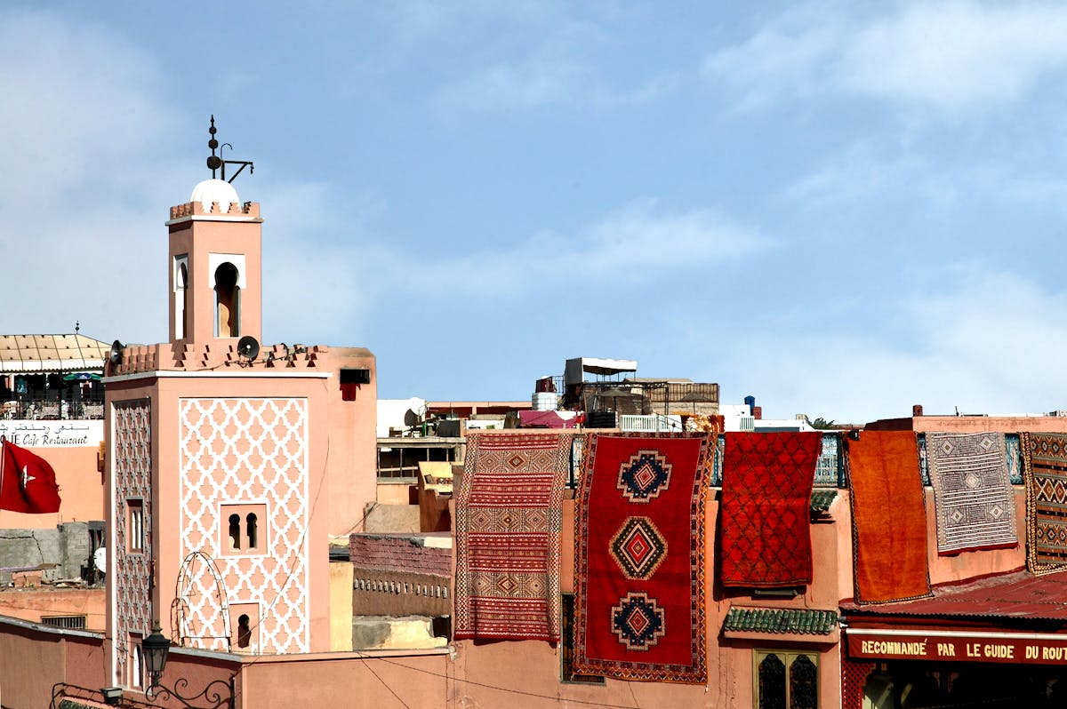 Marrakech rooftops with a pink minaret and Berber rugs hanging in the sun, Morocco