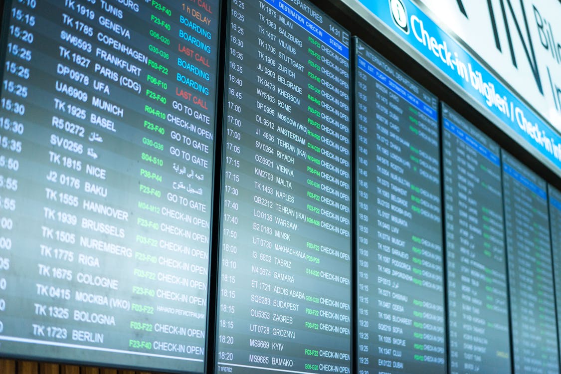 Airport departure screens showing flight information before a long-haul trip