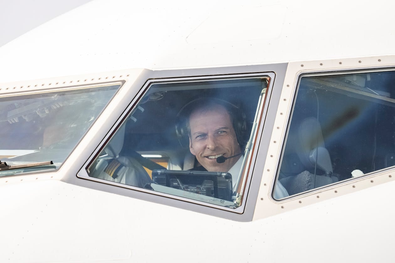 Commercial airline pilot smiling through cockpit window