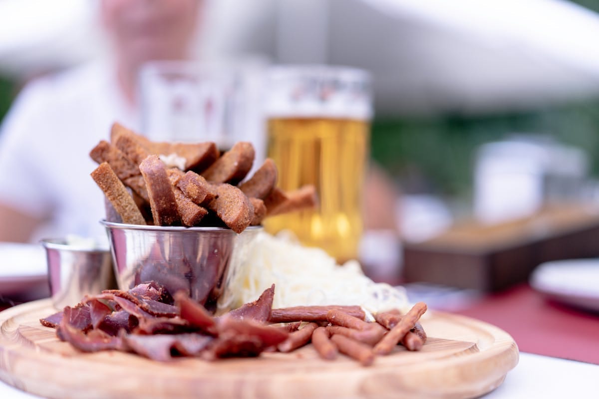 Hearty Czech pub food and beer served on a wooden board in a Prague hospoda