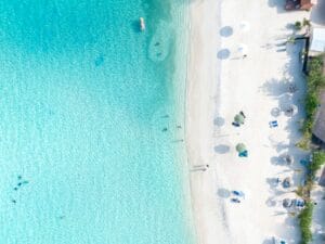 Aerial view of a white sand Caribbean beach with clear blue water
