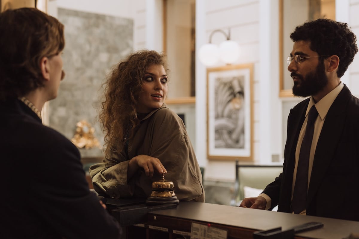 A family at a hotel reception desk checking in during school holidays