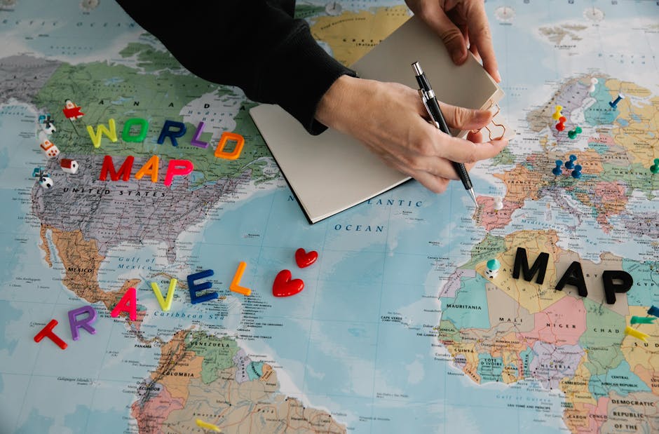 Person planning holiday with world map and pen