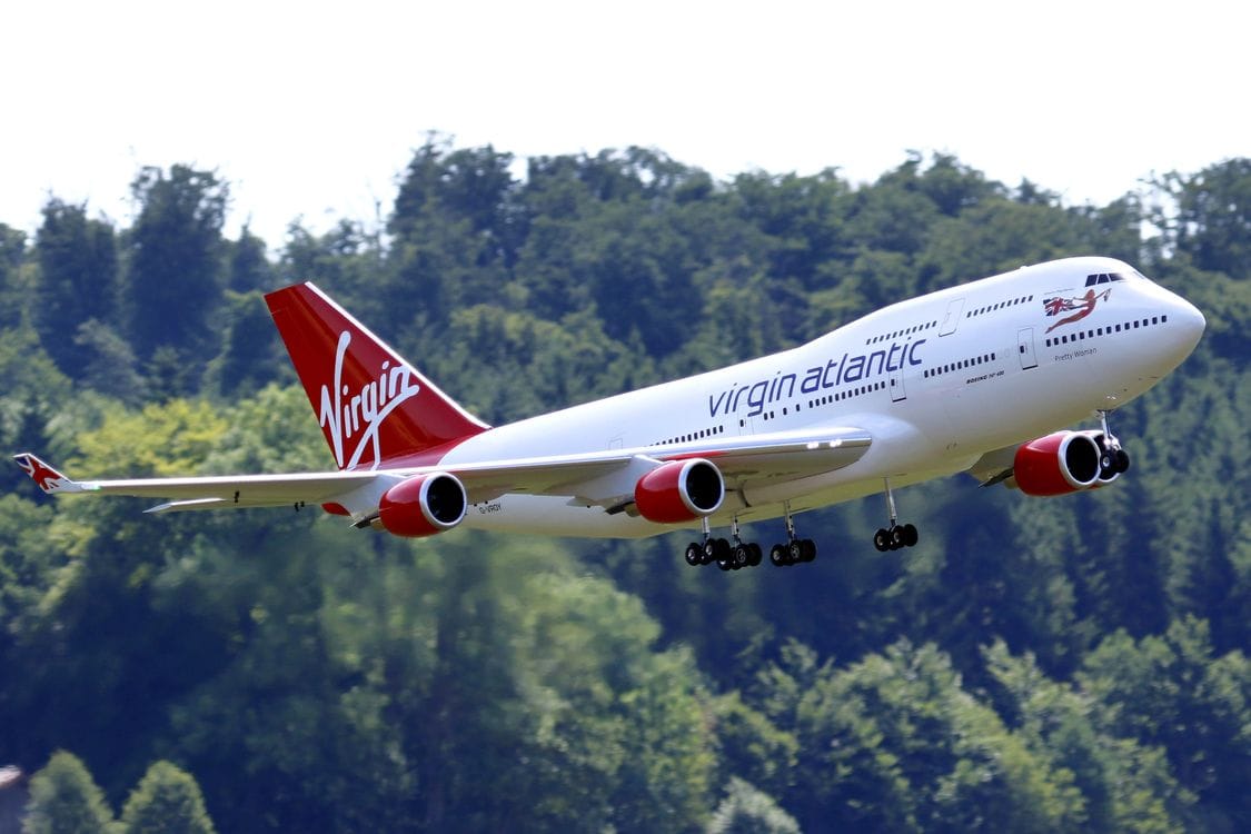 Close-up of a Virgin Atlantic model airplane in flight showing red tail and livery
