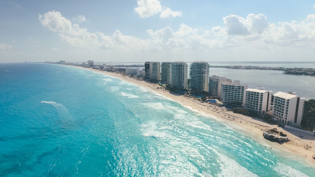 Aerial view of Cancún's Hotel Zone showing the sandy peninsula between the Caribbean Sea and the Nichupté Lagoon with beachfront resorts