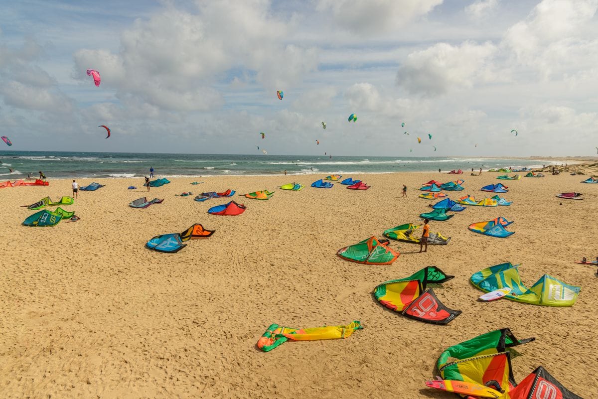 Kitesurfers on a wide sandy beach in Sal, Cape Verde, with steady trade winds