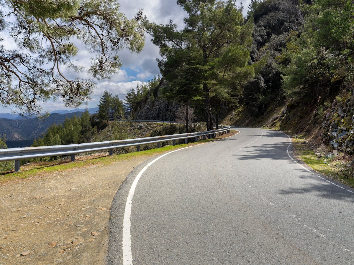 A winding mountain road through the pine forests of the Troodos range in Cyprus
