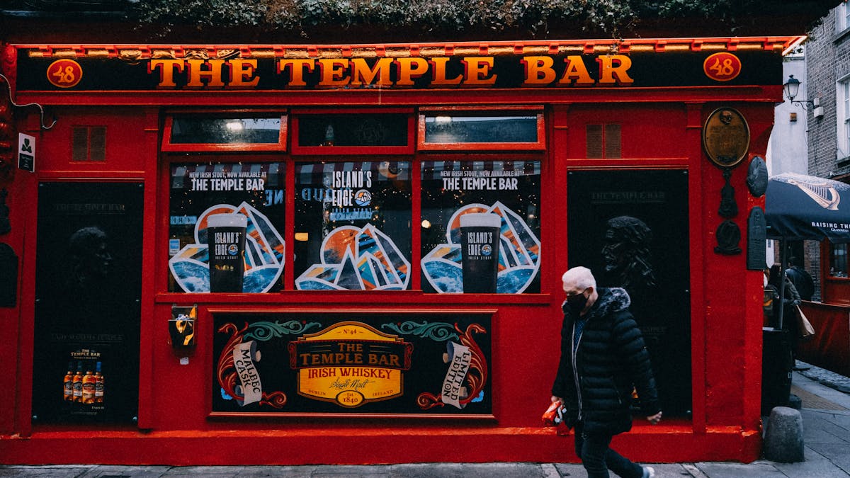 The bright red facade of the Temple Bar pub on a Dublin street