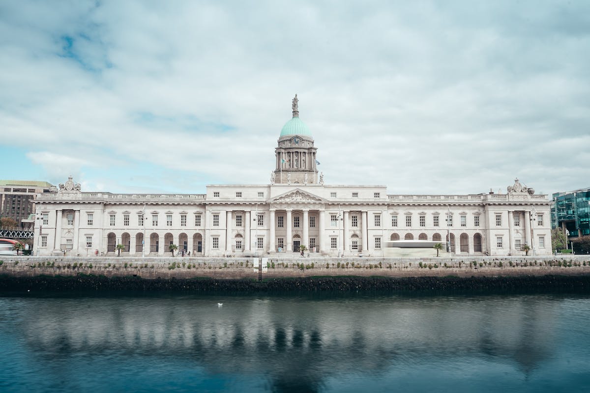 The Custom House reflected in the River Liffey in Dublin under a cloudy sky