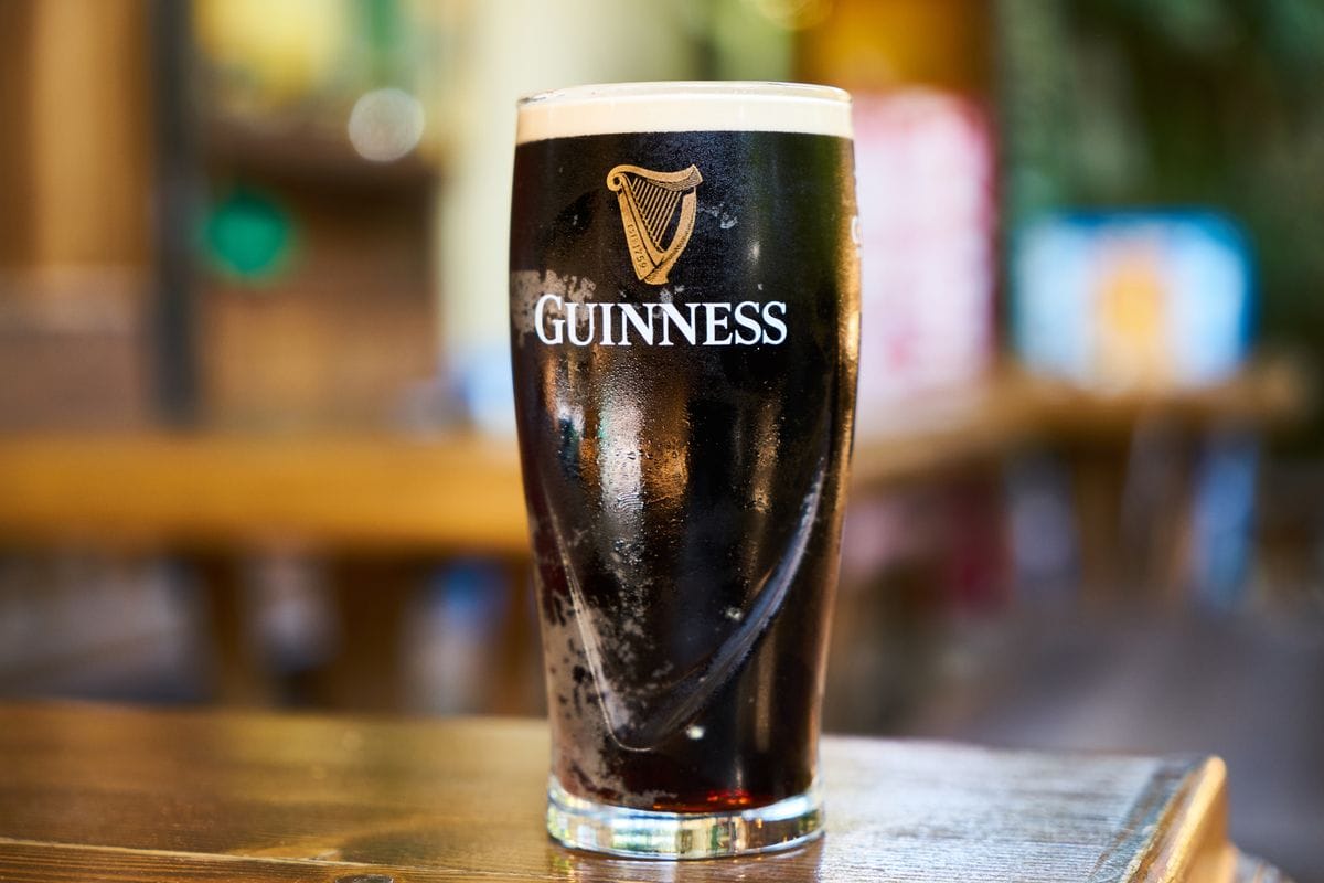 A pint of Guinness stout settling on a wooden pub table
