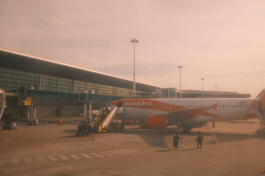 An easyJet aircraft parked at Porto airport under warm daylight, ready for boarding