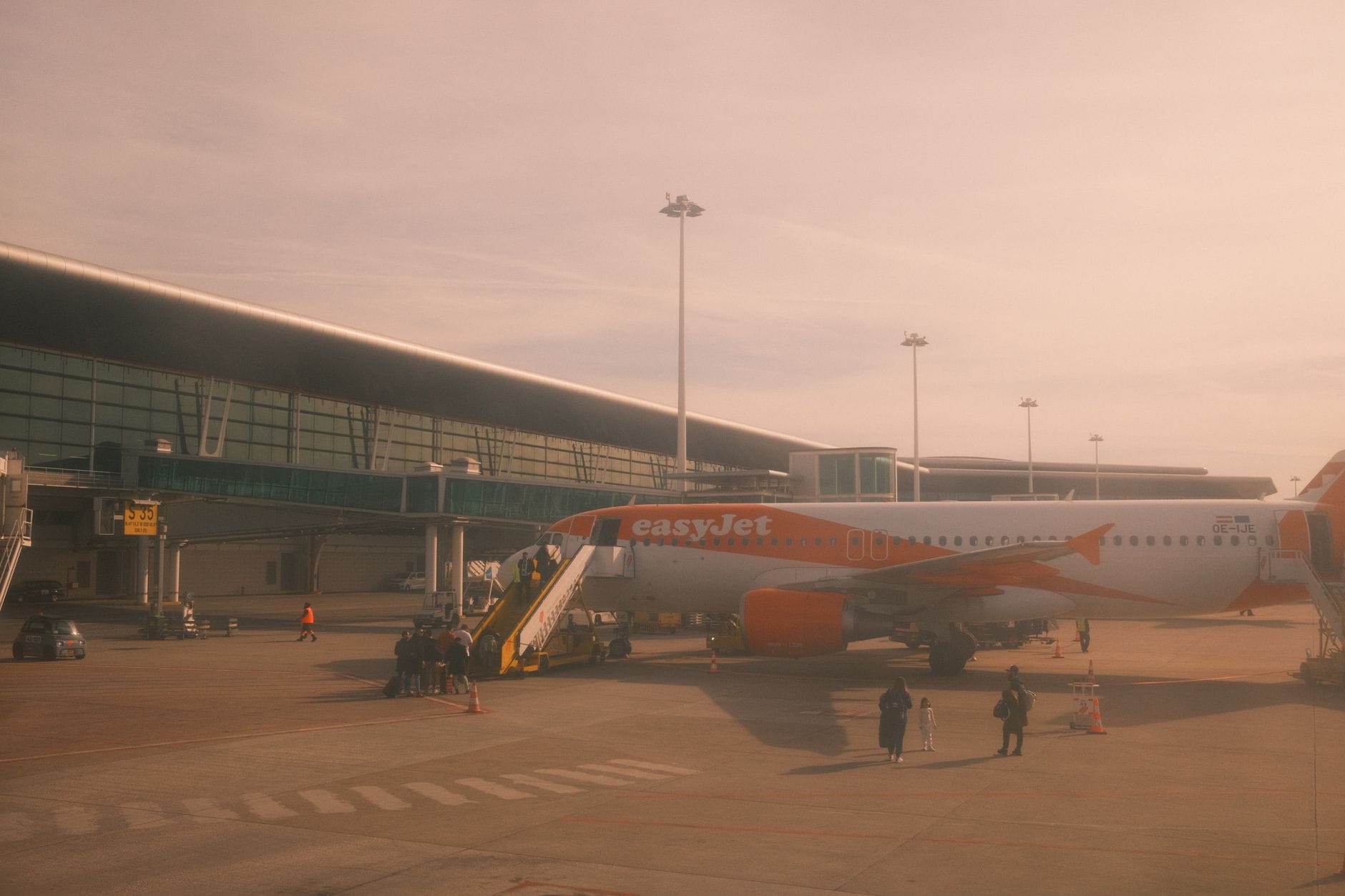 An easyJet aircraft parked at Porto airport under warm daylight, ready for boarding