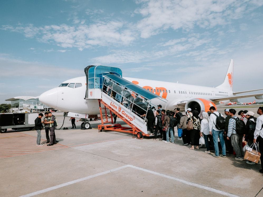 Passengers queuing to board an easyJet aircraft on the tarmac at a sunny airport