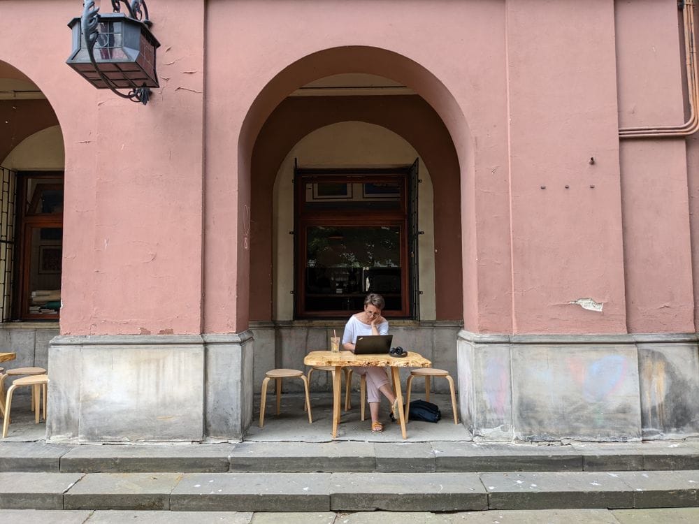 Digital nomad working on a laptop in a city coffee shop