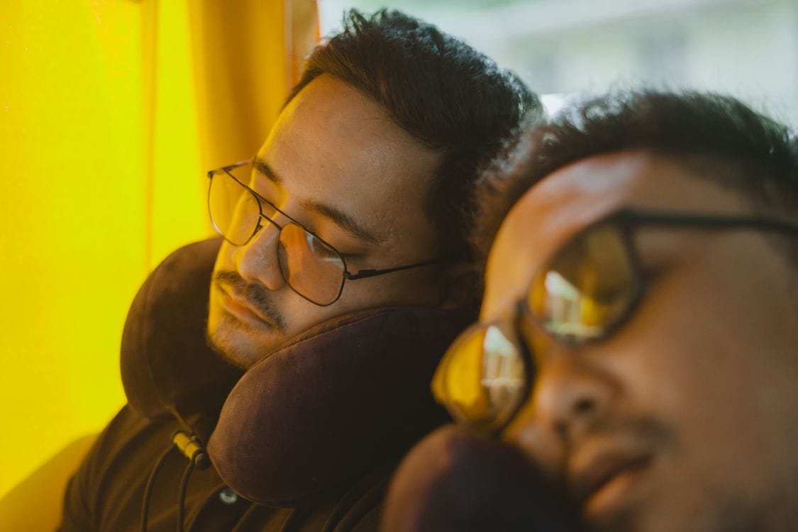 Passenger using a travel pillow to sleep on a long-haul flight