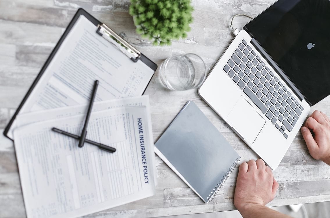 Travel insurance documents and passport on a desk