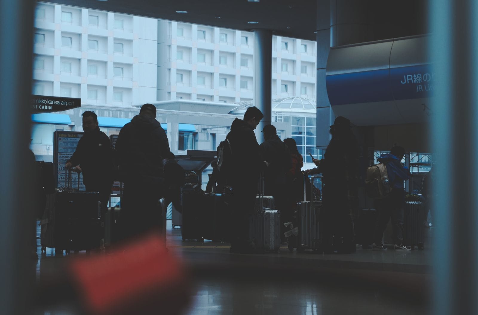 Travellers with suitcases waiting at a Japanese railway station