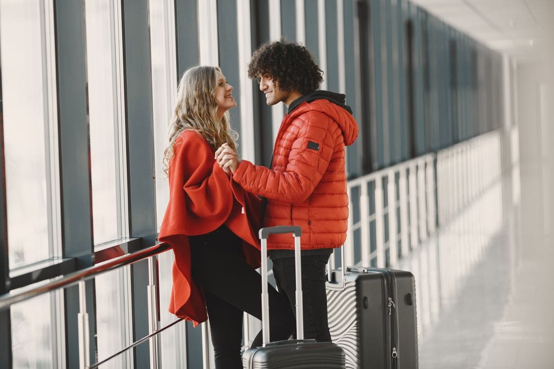 Couple with luggage at an airport terminal ready to check in