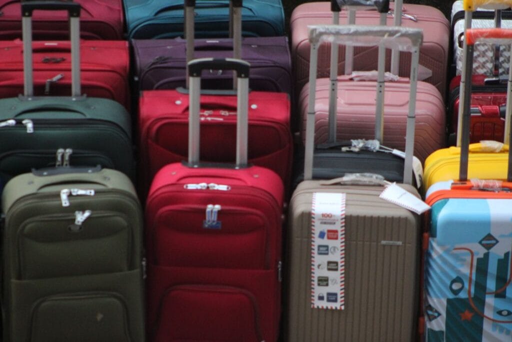 A collection of colourful suitcases stacked ready for travel