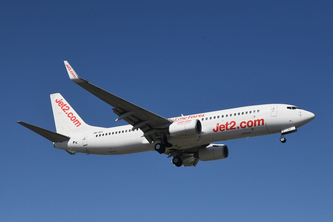 Jet2 Boeing aircraft in flight over Geneva with clear blue sky