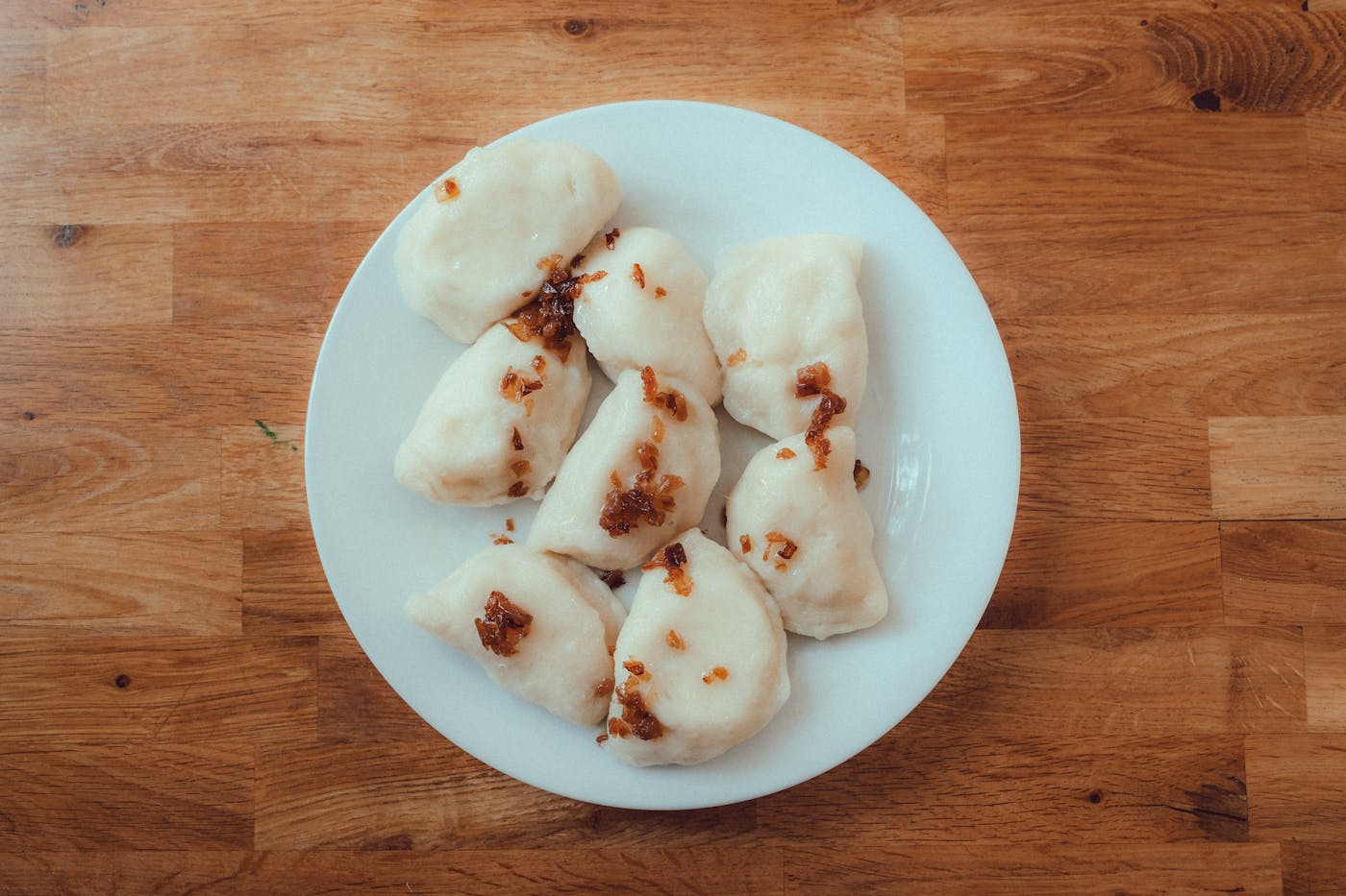A plate of Polish pierogi dumplings with crispy onions