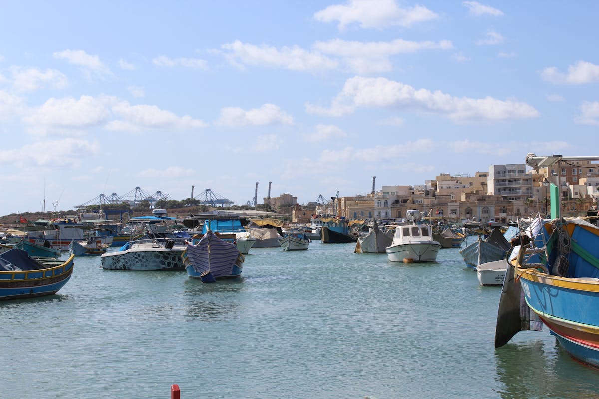 Colourful traditional luzzu fishing boats in Marsaxlokk harbour, Malta