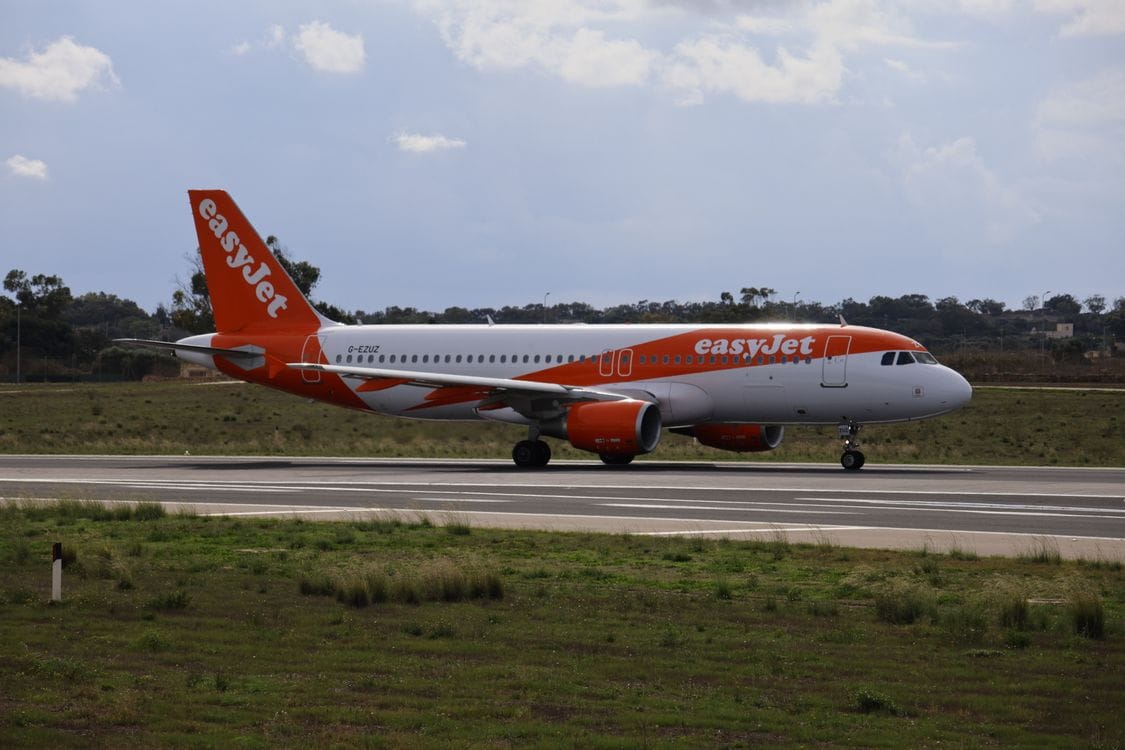easyJet A320 aircraft on a sunny airport runway ready for takeoff
