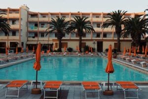 Poolside sunbeds and palm trees at a Mediterranean resort